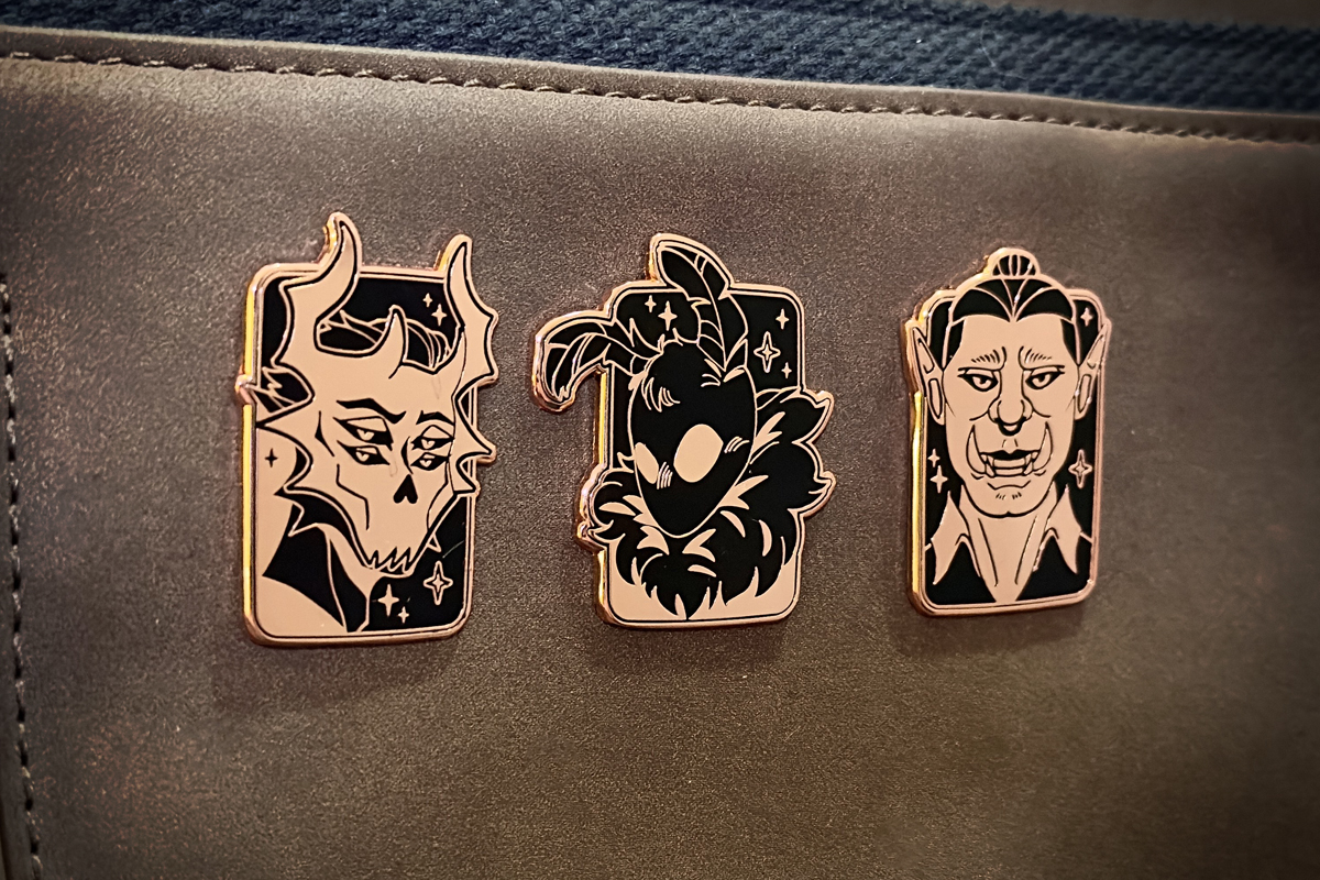 Monster Romance-themed Enamel Pins on bag